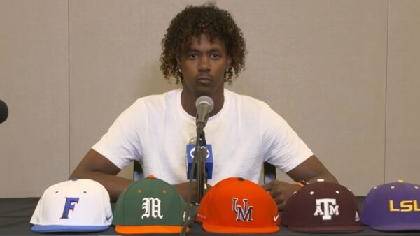 Jaden Rashada with hats in front of him