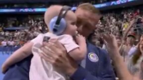 Caeleb Dressel holds his baby son after winning a gold medal