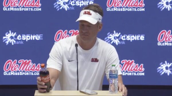 Lane Kiffin looks at a bottle of Coke